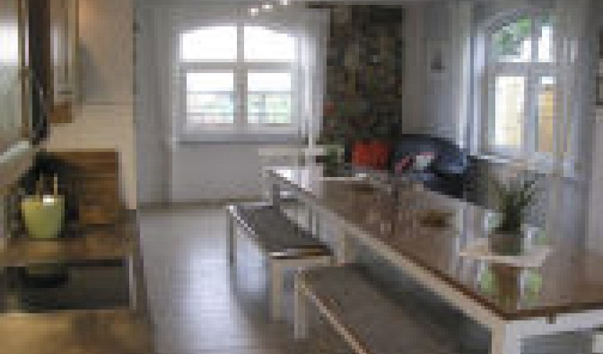 der zum Ferienhaus gehörige Gemeinschaftsraum mit Kamin, Küche und Bad