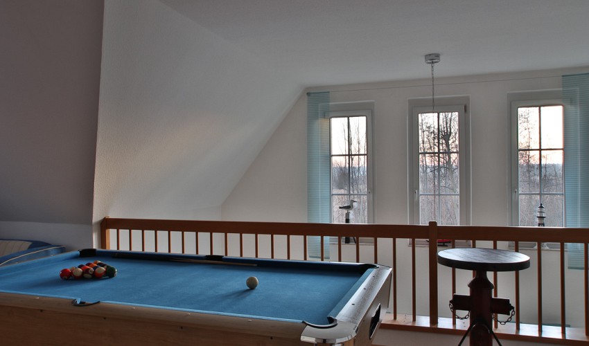 Blick über den Billardtisch ins Wohnzimmer