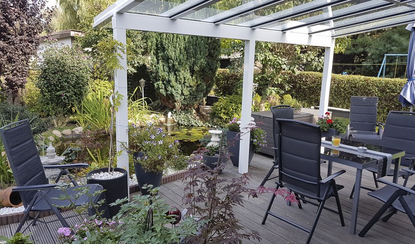 überdachte Terrasse mit Blick in den Garten